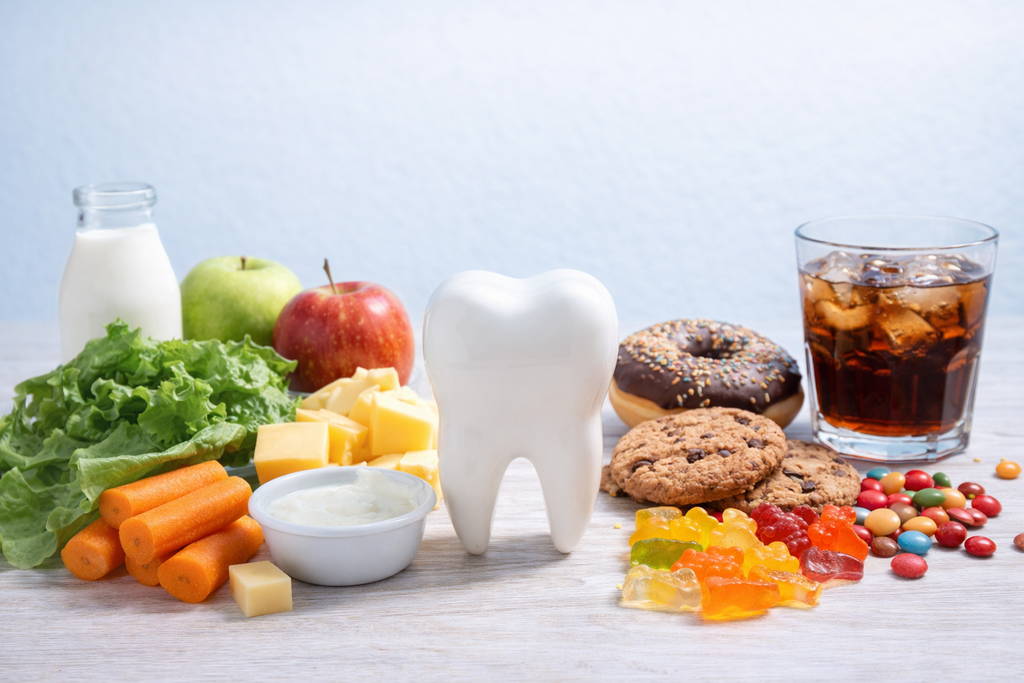How Diet Affects Your Oral Health Healthy and unhealthy foods affecting oral health including fruits, vegetables, dairy, candy, and soda